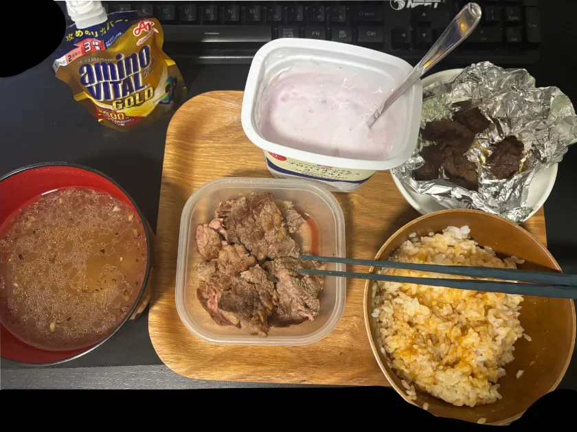 木目トレー上に並べられた牛肉、卵かけご飯、スープ、ヨーグルト、アミノバイタル。運動後のタンパク質やアミノ酸補給を意識した高タンパクな食事。